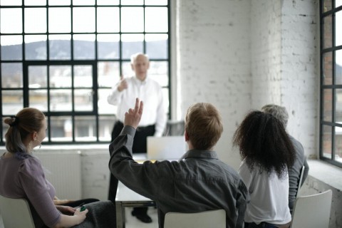 Group of people together, one person holding their hand up